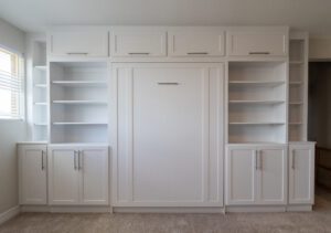 Vertical queen Murphy bed with custom cabinetry and recessed bookcases