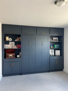 Queen Craftsman Murphy bed with built-in cabinets showing client decor