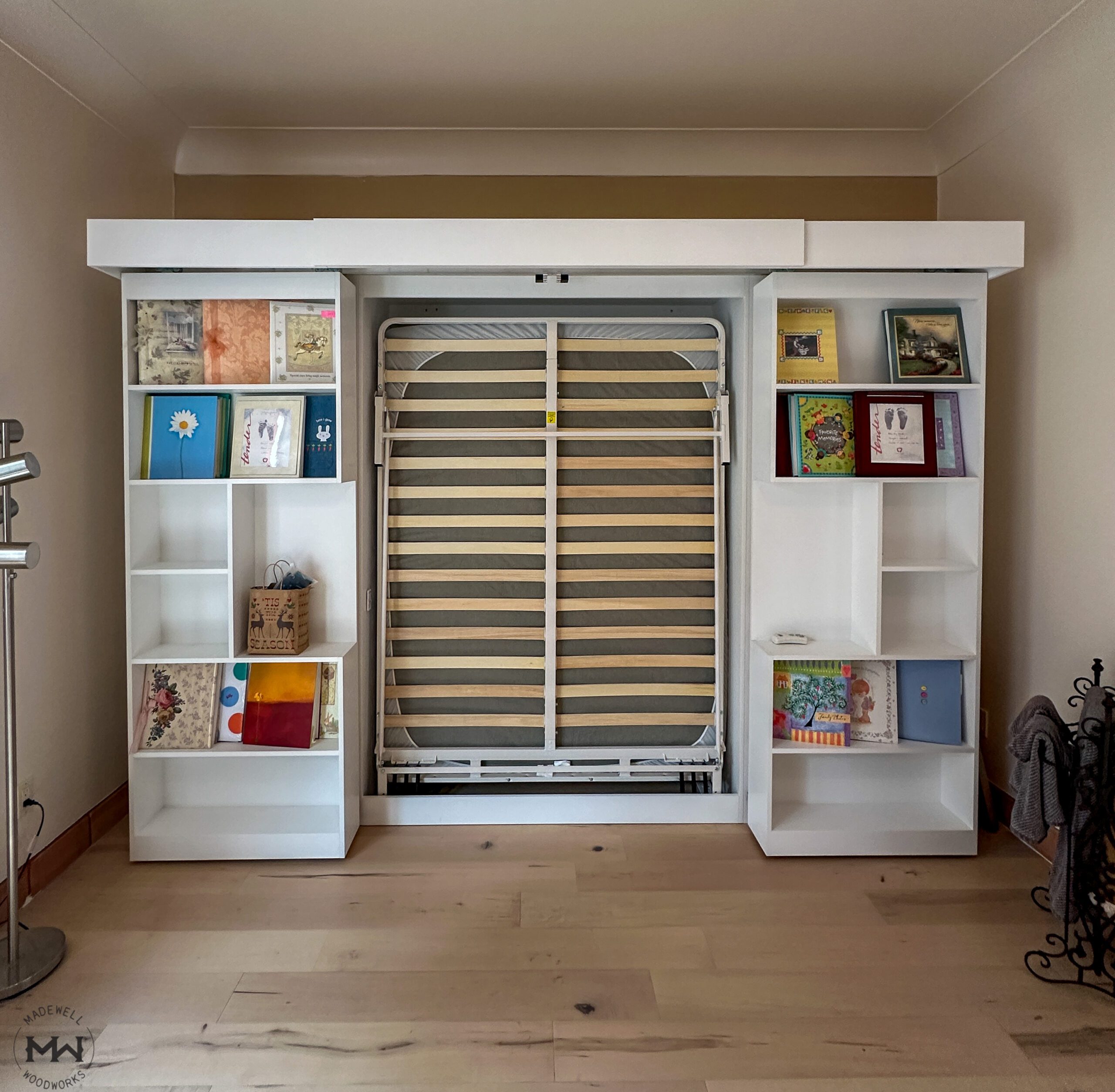 Built-in sliding bookcase Murphy bed in open position showing bed platform, installed in Travis Heights Austin TX by Madewell Woodworks