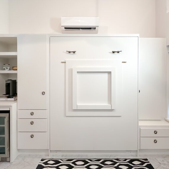 Custom white Murphy bed with folding dek front, built-in drawers, and beverage nook, handcrafted by Madewell Woodworks in Austin, Texas.