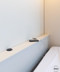 Built-in USB-C charging ports and power outlets on a custom Murphy bed shelf, handcrafted by Madewell Woodworks in Austin, Texas.