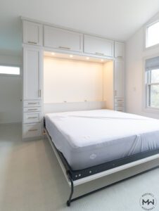 Custom king-size Murphy bed with integrated LED lighting, shaker-style cabinetry, and gold hardware, handcrafted by Madewell Woodworks in Austin, Texas.