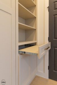 Dedicated pull-out nightstand inside of cabinet attached to custom-built Murphy bed