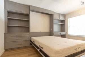 Custom gray Craftsman Murphy bed with built-in desk, shelving, and upper cabinetry, handcrafted in Austin by Madewell Woodworks.