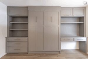 Custom gray queen Craftsman Murphy bed with built-in desk, shelving, and upper cabinetry, handcrafted in Austin by Madewell Woodworks.