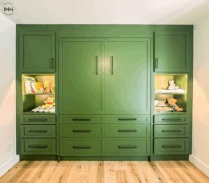 Custom green built-in Murphy bed with integrated shelving, accent lighting, and black hardware, handcrafted in Austin by Madewell Woodworks.