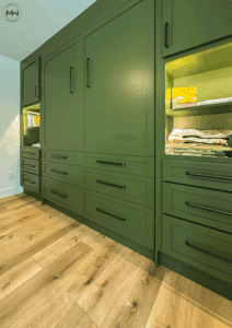 Custom green Murphy bed with built-in drawers, shelving, and accent lighting, handcrafted in Austin by Madewell Woodworks.