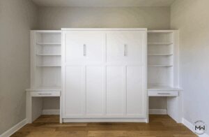 King-size white Murphy bed with dual built-in desks and shelving, handcrafted by Madewell Woodworks in Austin, Texas.