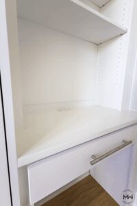 Close-up of king-size white Murphy bed desk with built-in charging ports and modern hardware, handcrafted by Madewell Woodworks in Austin, Texas.