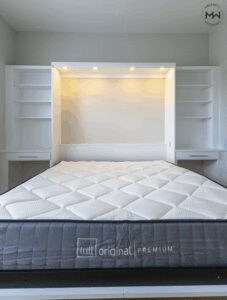 King-size white Murphy bed with built-in lighting, shelving, and dual desks, handcrafted by Madewell Woodworks in Austin, Texas.