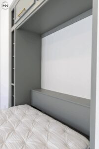 Close-up of a custom light green Murphy bed interior with soft gold hardware and clean, modern lines, handcrafted by Madewell Woodworks in Austin, Texas.