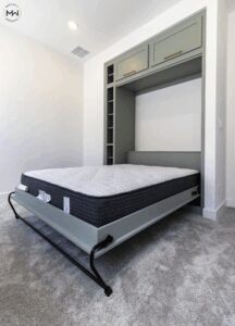 Light green Murphy bed with the frame open, featuring gold hardware and integrated side shelving, custom built by Madewell Woodworks in Austin, Texas.