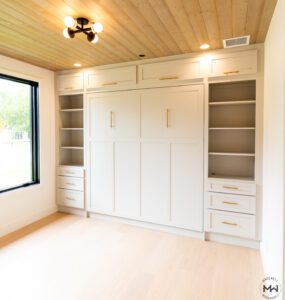 Custom neutral Craftsman-style Murphy bed with built-in shelving and gold hardware, handcrafted in Austin by Madewell Woodworks.