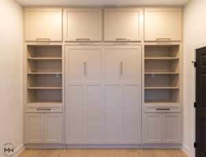 Custom neutral Craftsman-style Murphy bed with upper cabinets and built-in shelving, handcrafted in Austin by Madewell Woodworks.