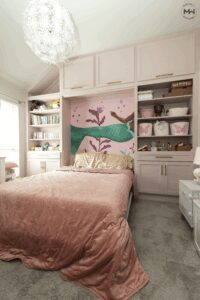 Pink Crestview Murphy bed with built-in shelving and a mermaid wall mural in a children’s bedroom.
