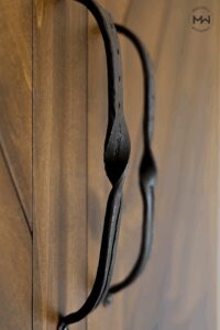 Close-up of hand-forged iron hardware on a custom maple Chevron Murphy bed, showcasing artisan detail and craftsmanship by Madewell Woodworks in Austin, Texas.