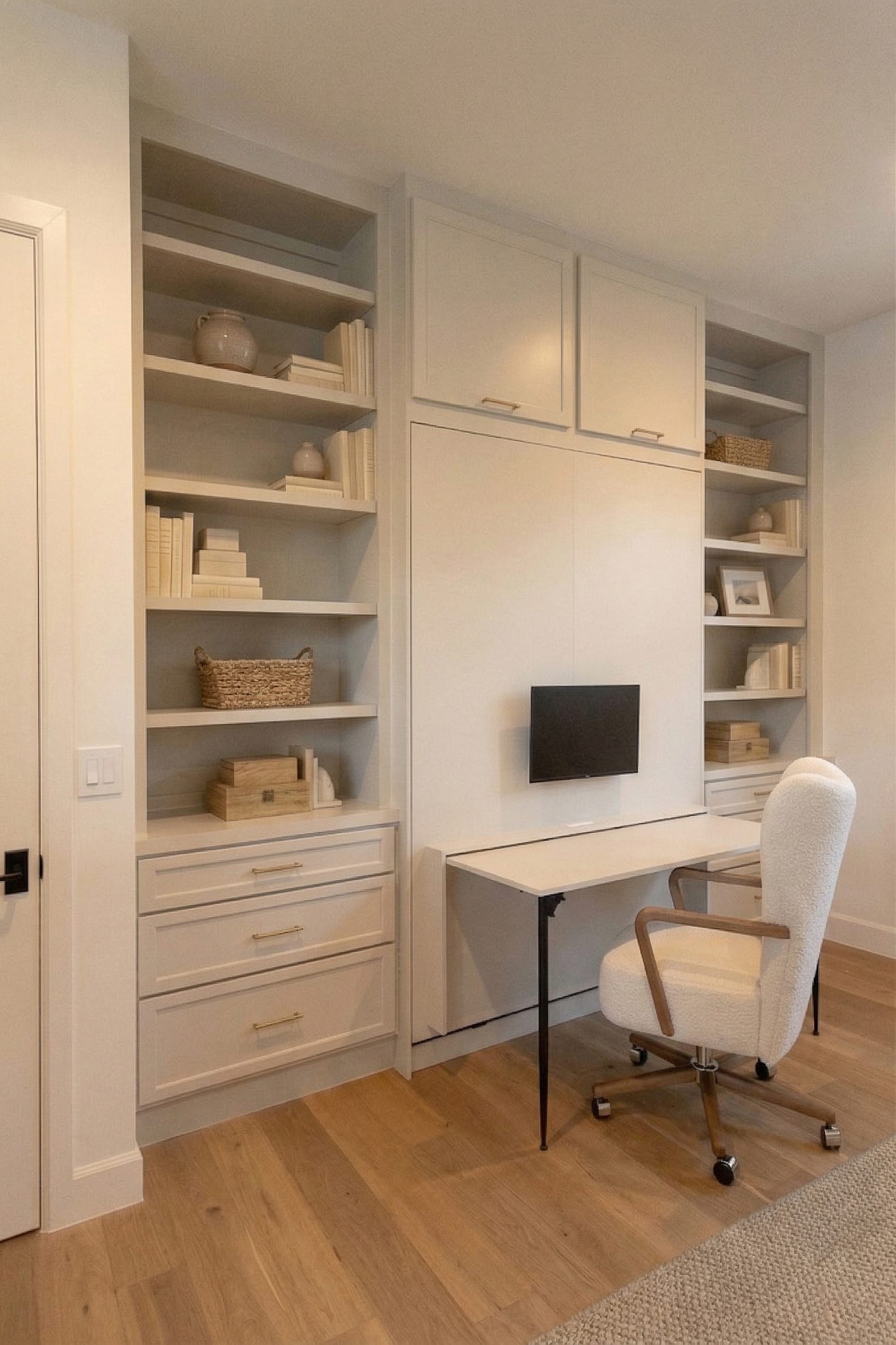Revere Pewter Murphy bed with fold-down drop desk deployed, open shelving towers, and office chair in Northwest Hills Austin home office
