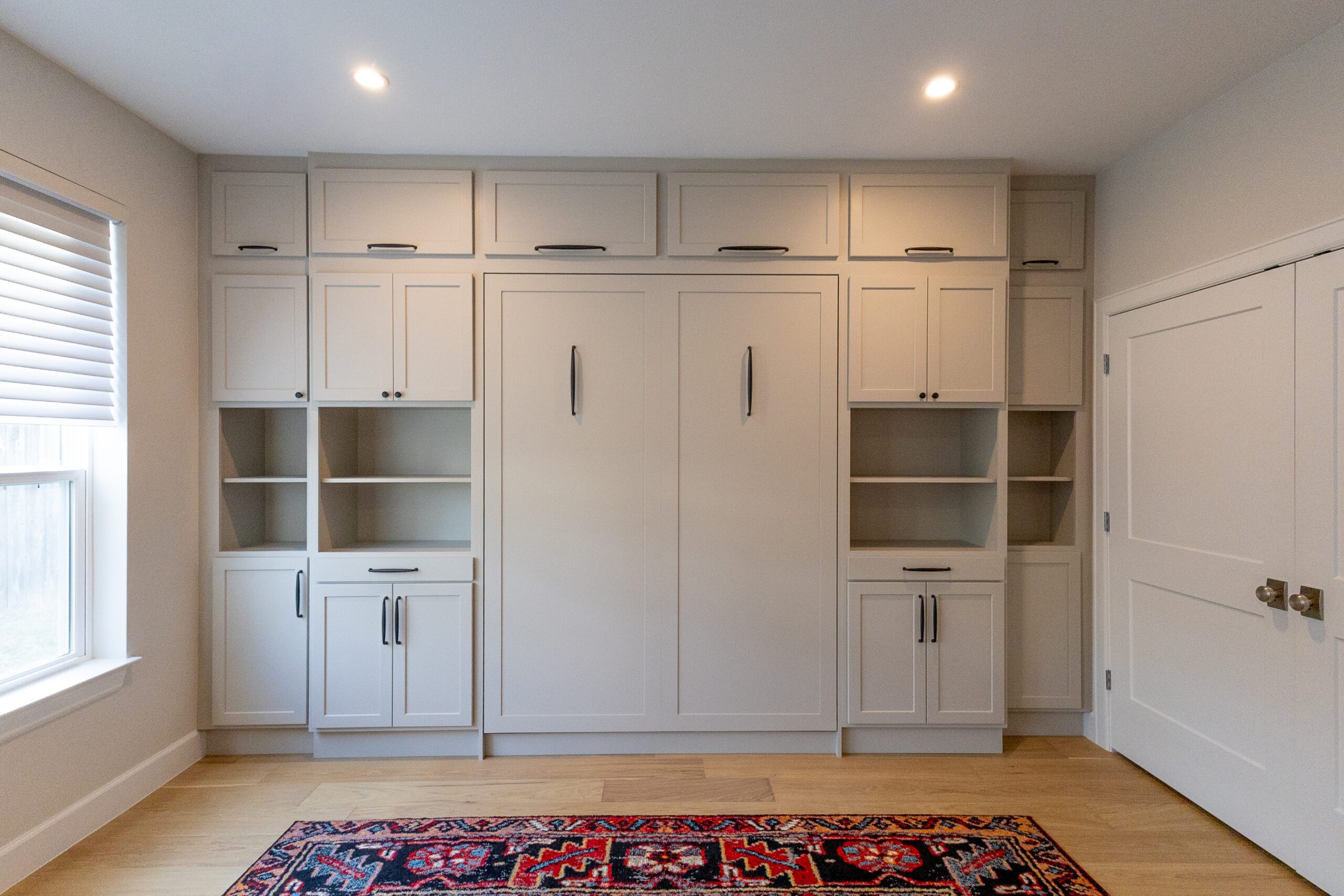 Custom built-in Murphy bed with floor-to-ceiling wall cabinetry, Georgetown TX