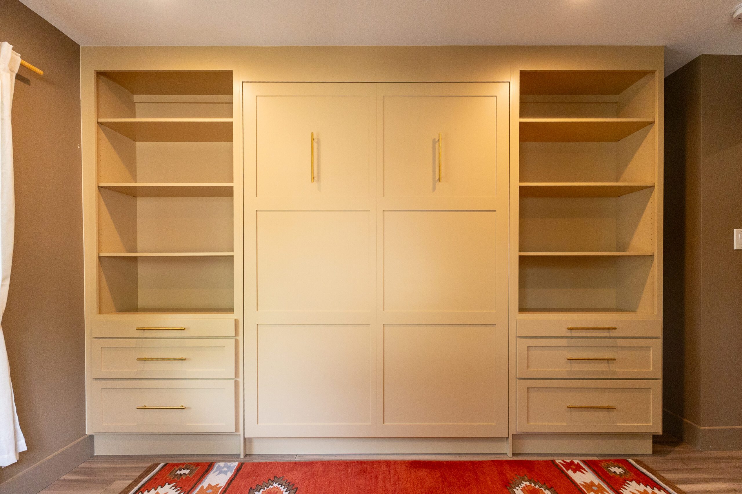 Queen vertical Shaker Murphy bed stowed with open shelving towers and drawer bases, Twilight Gold finish with gold pulls, Balcones Woods Austin TX